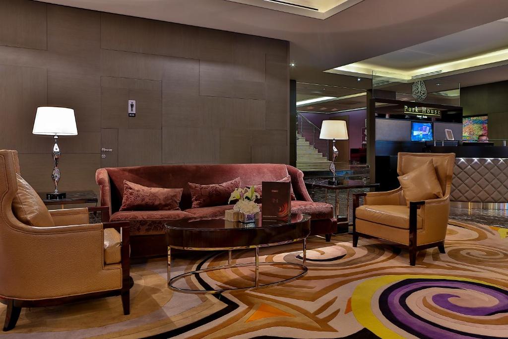 a lobby with a couch and two chairs and a table at Park House in Riyadh