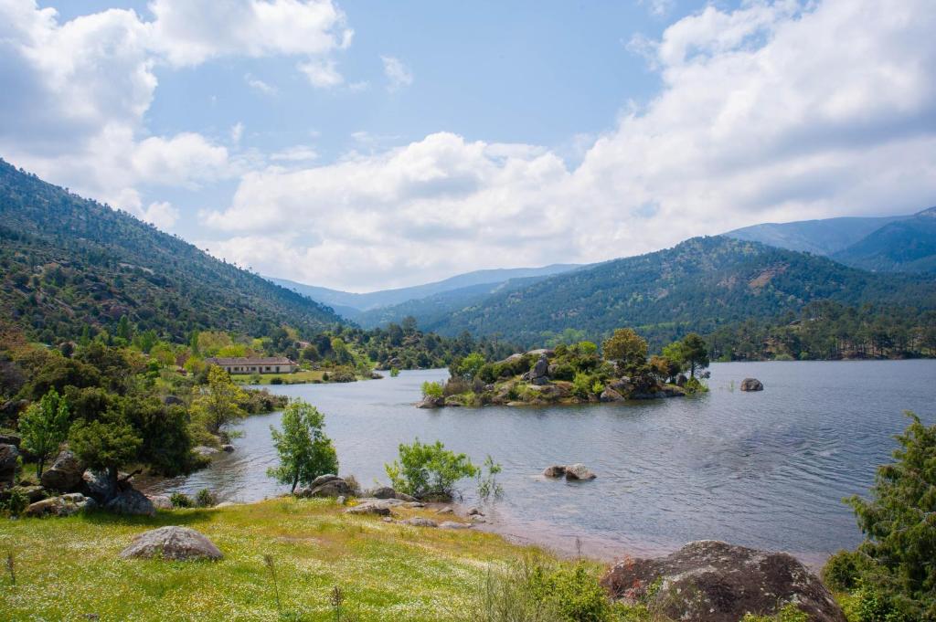 a view of a lake with mountains in the background at Núcleo de Turismo Rural Valle de Iruelas in Las Cruceras