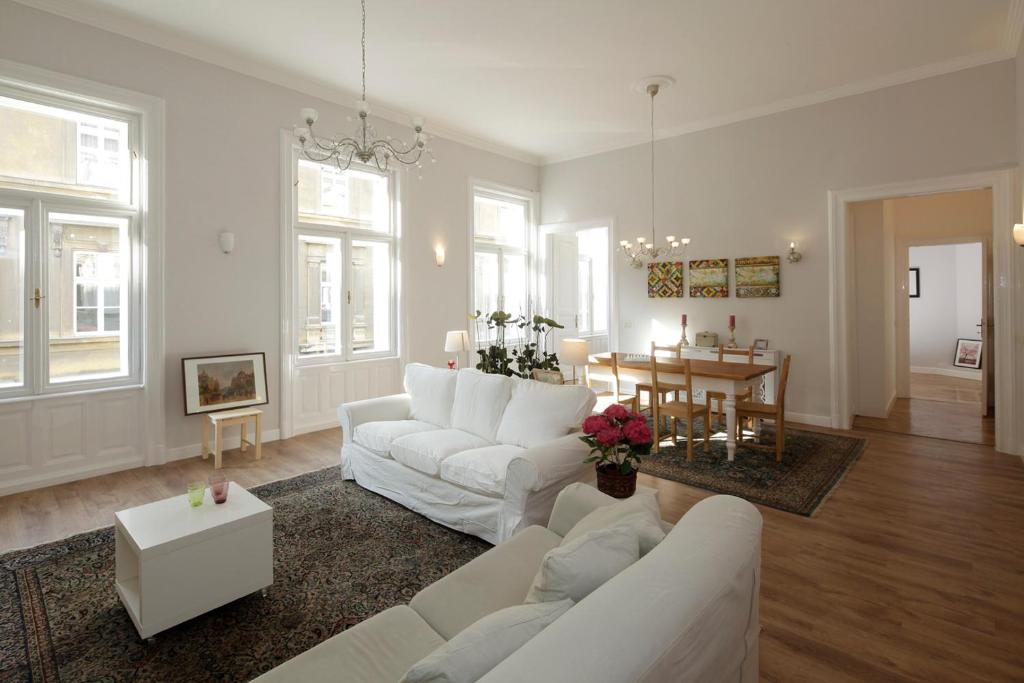 a living room with white furniture and a dining room at Victoria's Rooms 3 Bedrooms & 3 Baths, Free parking in Budapest
