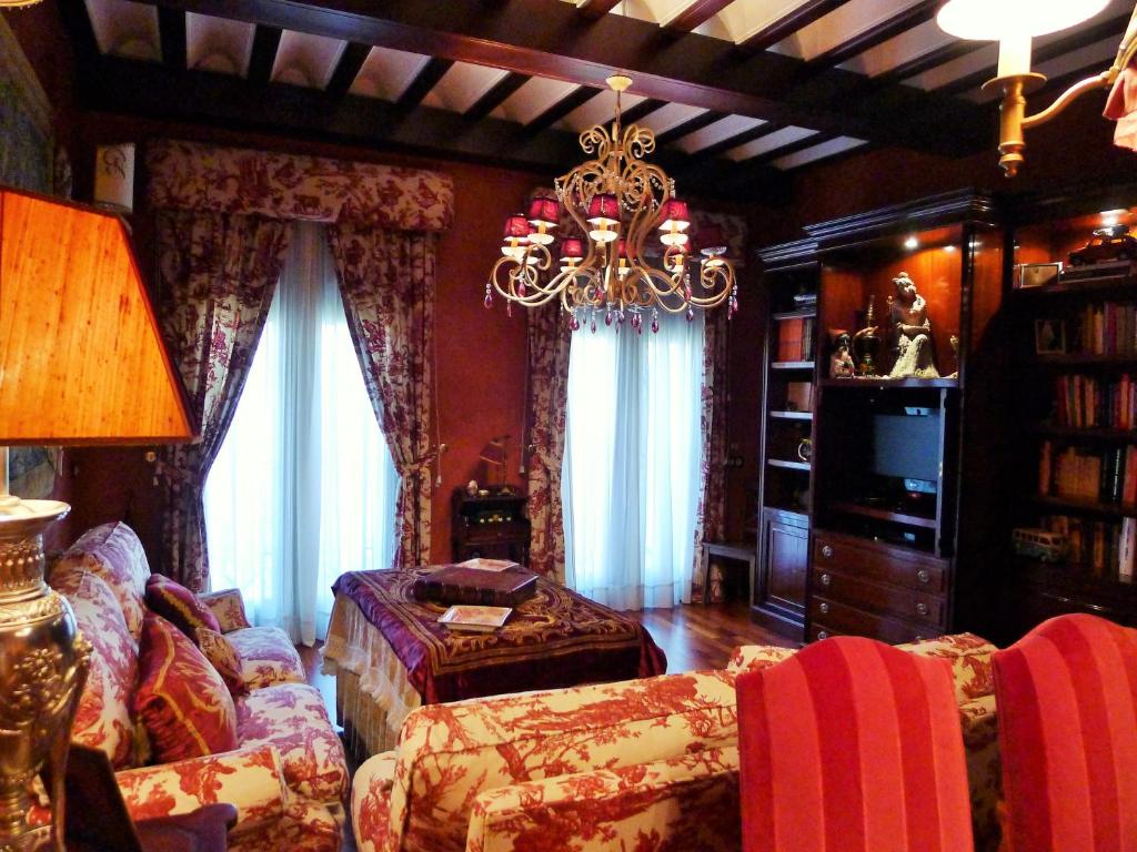 uma sala de estar com um sofá e um lustre em Plaza San Francisco luxury apt em Sevilha