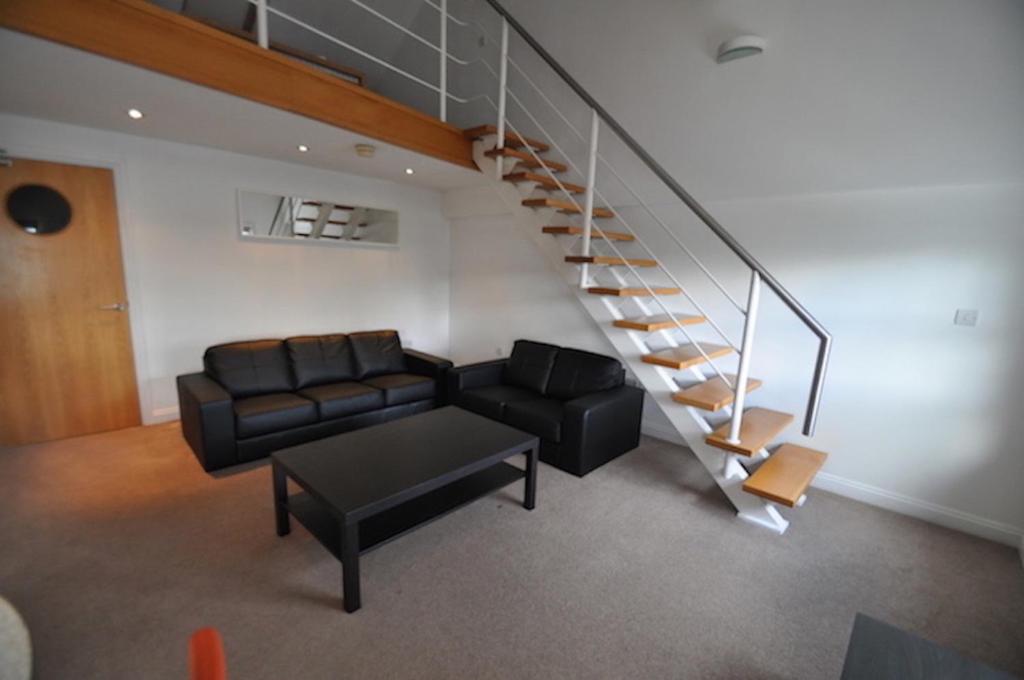 a living room with a couch and a staircase at Princes Dock Chambers 10 in Hull