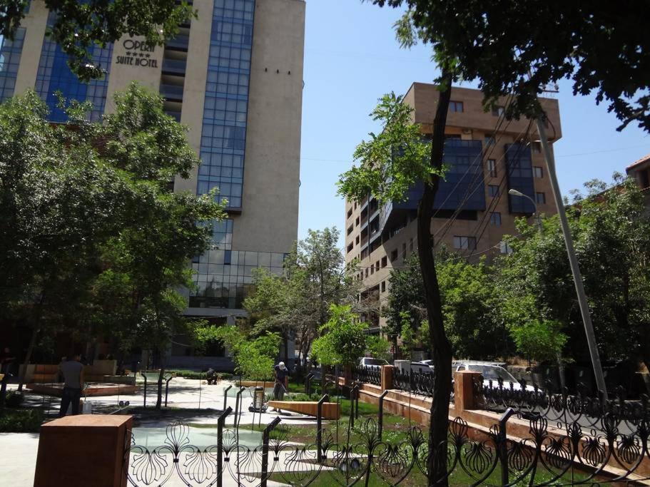 ein Park in einer Stadt mit hohen Gebäuden in der Unterkunft Cascade - Opera Apartment in Yerevan