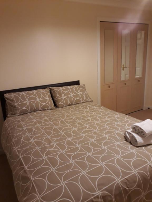 a bedroom with a large bed with a pillow at Handy Dale House in Bathgate
