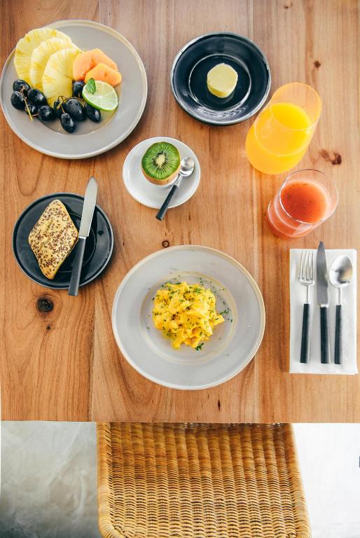 a wooden table with plates of food on it at Lagos Avenida Hotel in Lagos