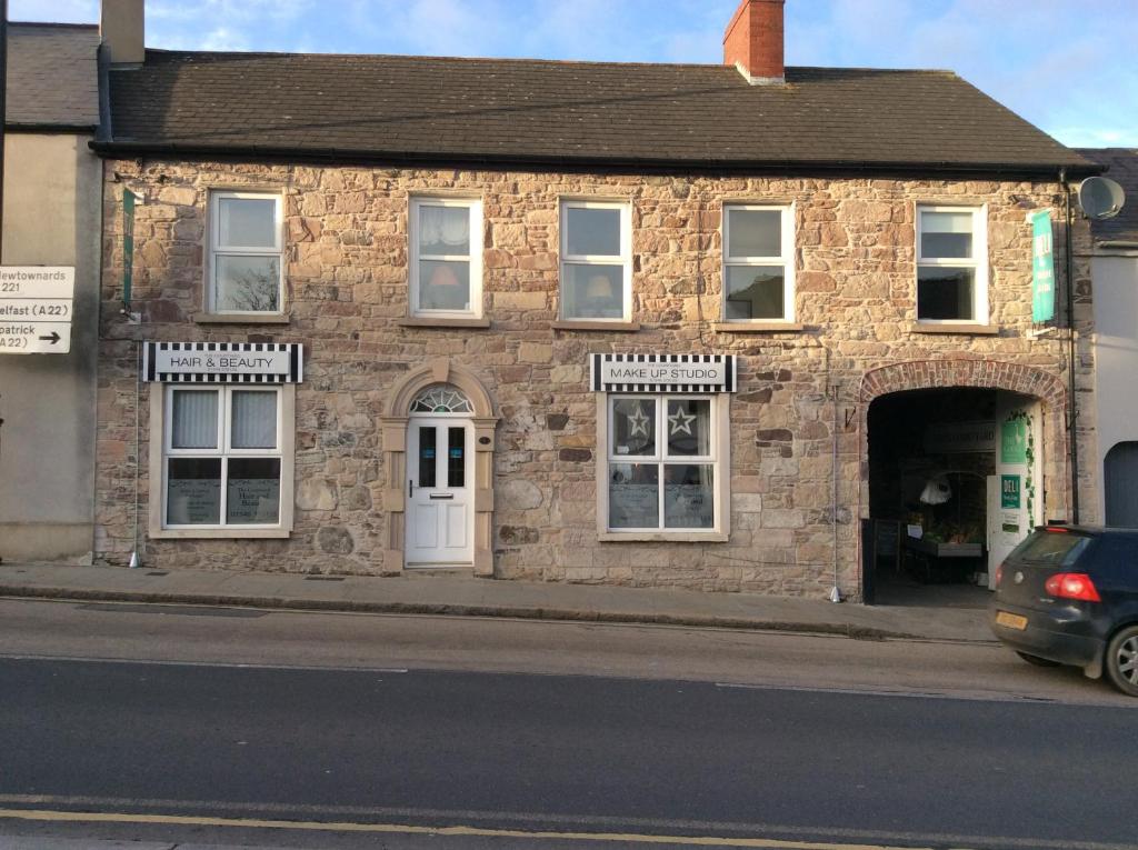a stone building with a car parked in front of it at Comber Courtyard Apartment in Comber