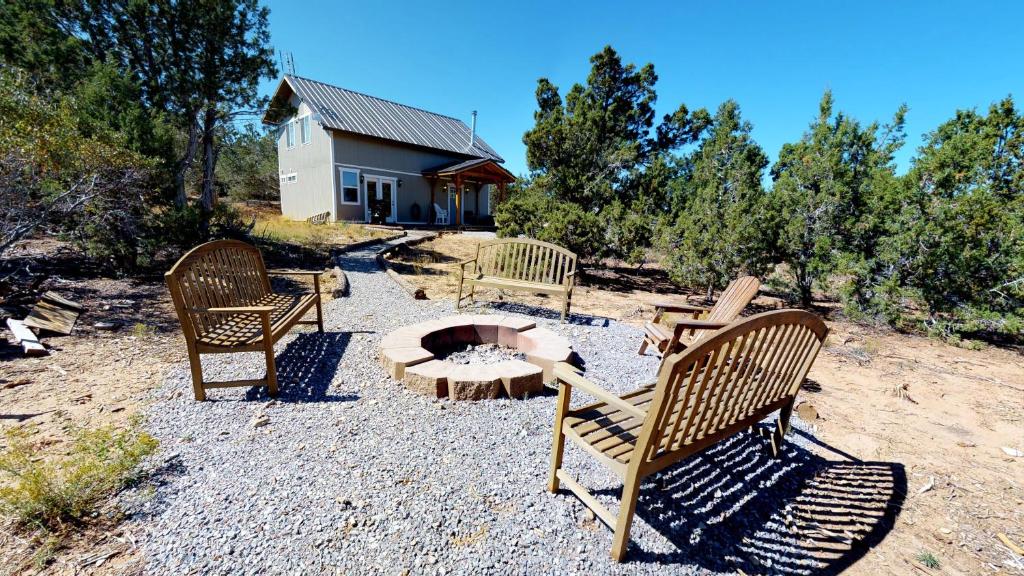 The Cedars Country Cottage, Solitude, Amazing Night Skies!! في بلاندينغ: مجموعة من الكراسي يجلسون حول حفرة النار