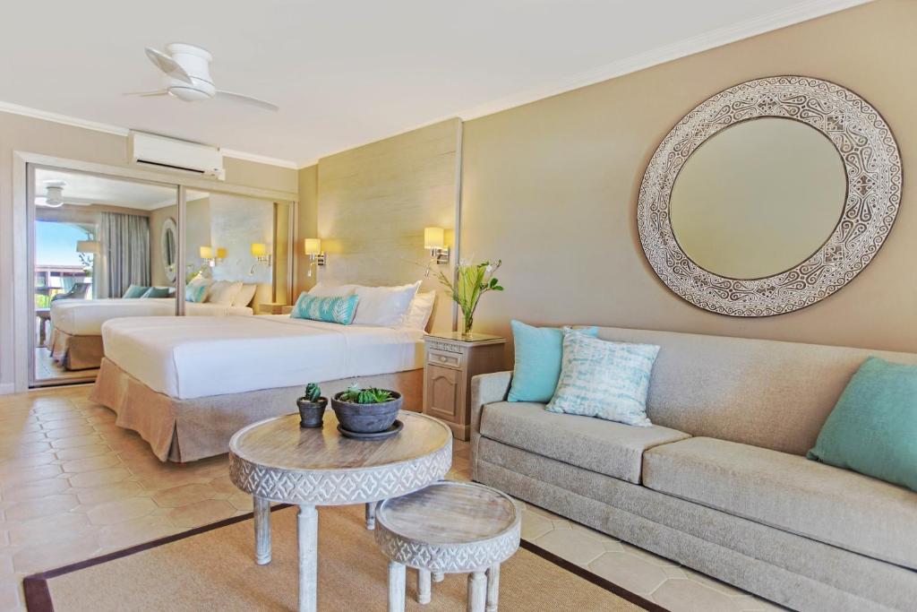 a hotel room with a bed and a couch at Bougainvillea Barbados in Christ Church