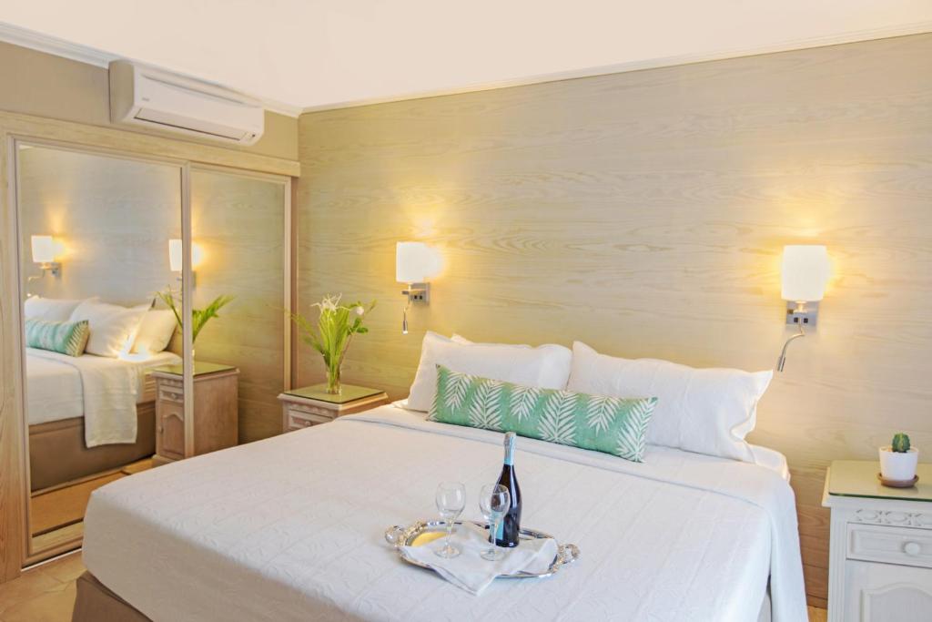 a bedroom with a large white bed with a tray on it at Bougainvillea Barbados in Christ Church