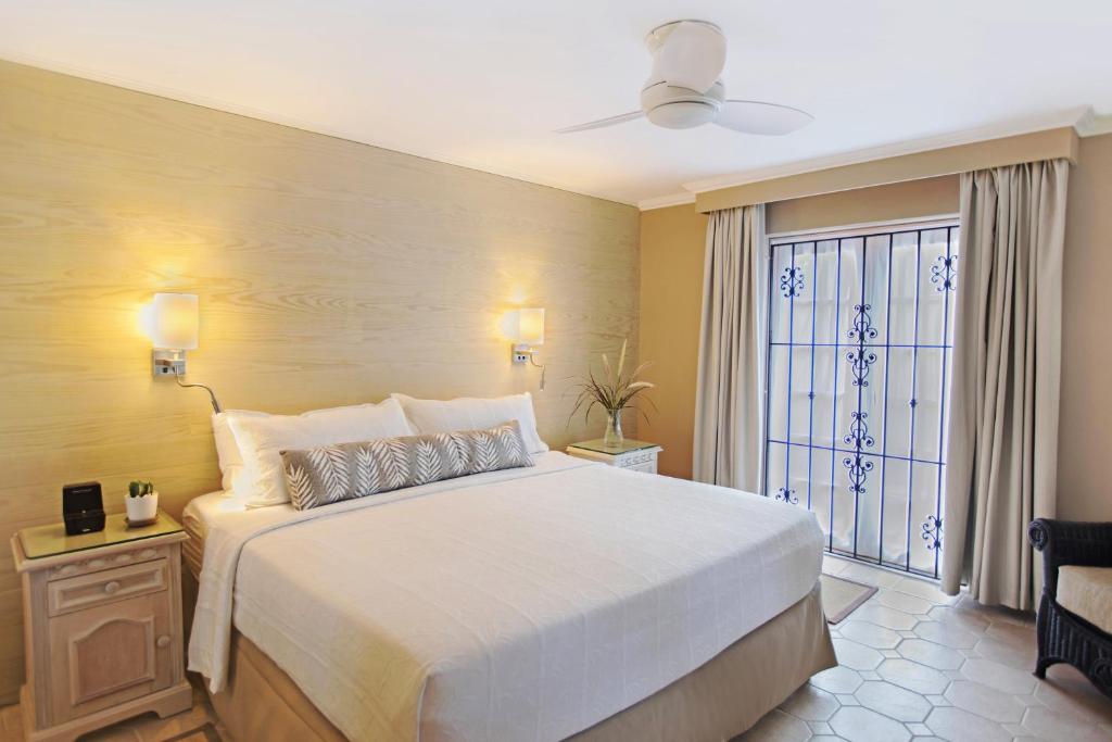a bedroom with a large bed and a window at Bougainvillea Barbados in Christ Church