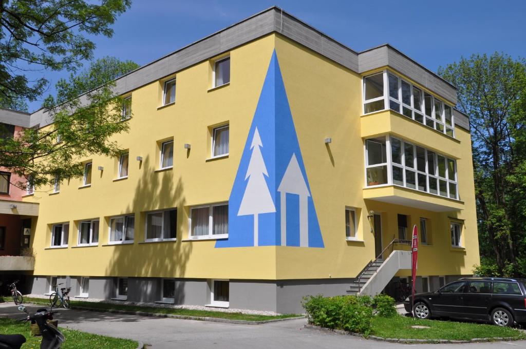 a yellow building with a blue arrow painted on it at Eduard-Heinrich-Haus, Hostel in Salzburg
