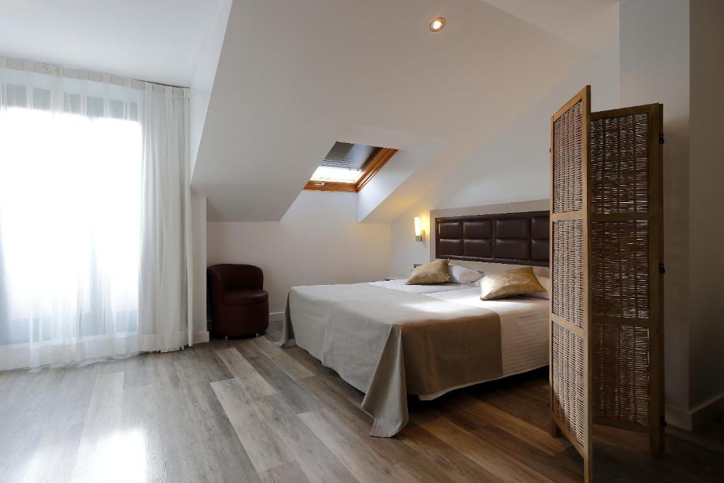 a bedroom with a large bed and a window at Hotel Santa Rosa, Blue Hoteles in Gijón