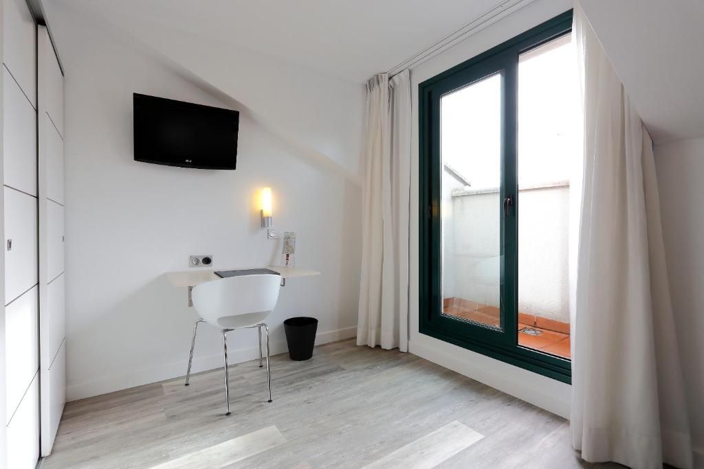 a white room with a table and a window at Hotel Santa Rosa, Blue Hoteles in Gijón
