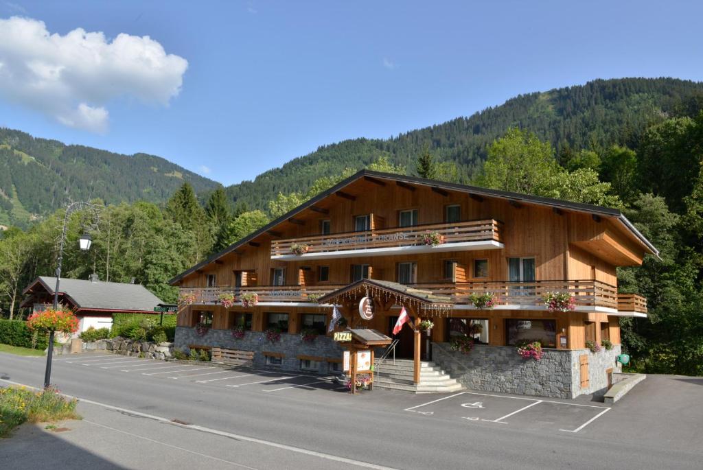 a large wooden building on the side of a road at Auberge de la Dranse in Châtel