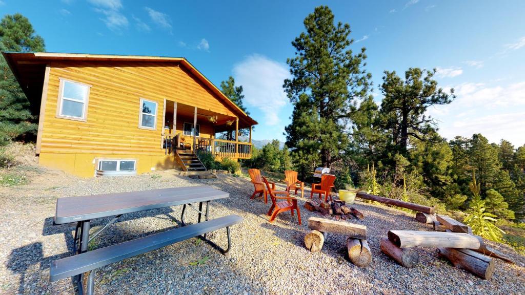 una casa con una mesa de picnic y sillas frente a ella en Long View Cabin, Breakfast Deck overlooking the Canyon! en Monticello
