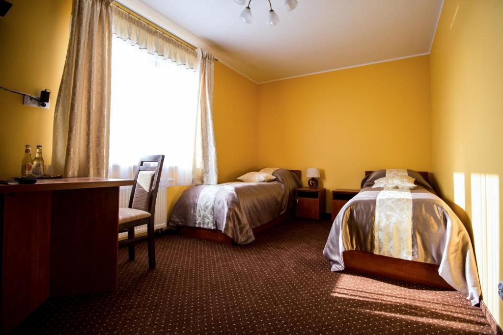 um quarto com 2 camas e uma janela em Park Hostel em Suchedniów