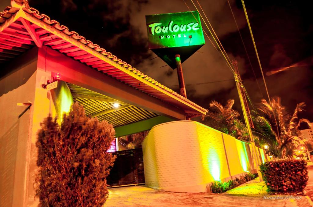 un panneau indiquant un restaurant tocoleasy avec un bâtiment dans l'établissement Toulouse Motel (Adult Only), à Natal