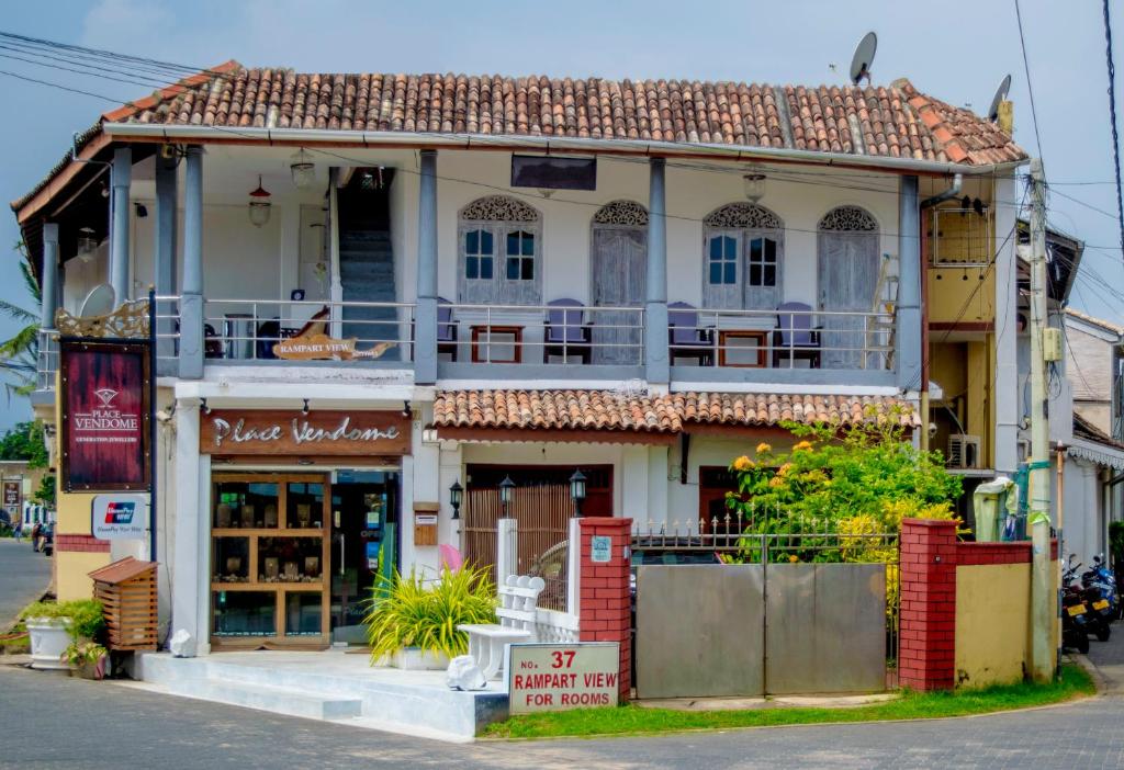 a house with a balcony on a street at Rampart View Guesthouse in Galle
