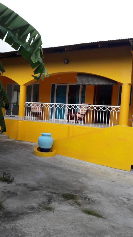 una casa amarilla con un tazón azul delante de ella en Beau Vallon Residence en Mahe