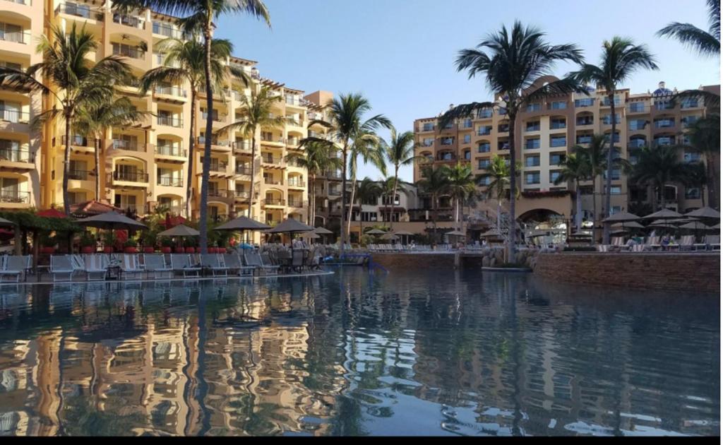 a pool of water with palm trees and buildings at Suites at VDP Flamingos Beach Resort and Spa in Nuevo Vallarta