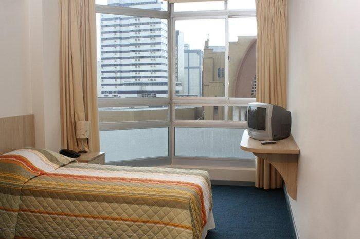 um quarto de hotel com uma cama e uma janela em Euro Hotel em Curitiba