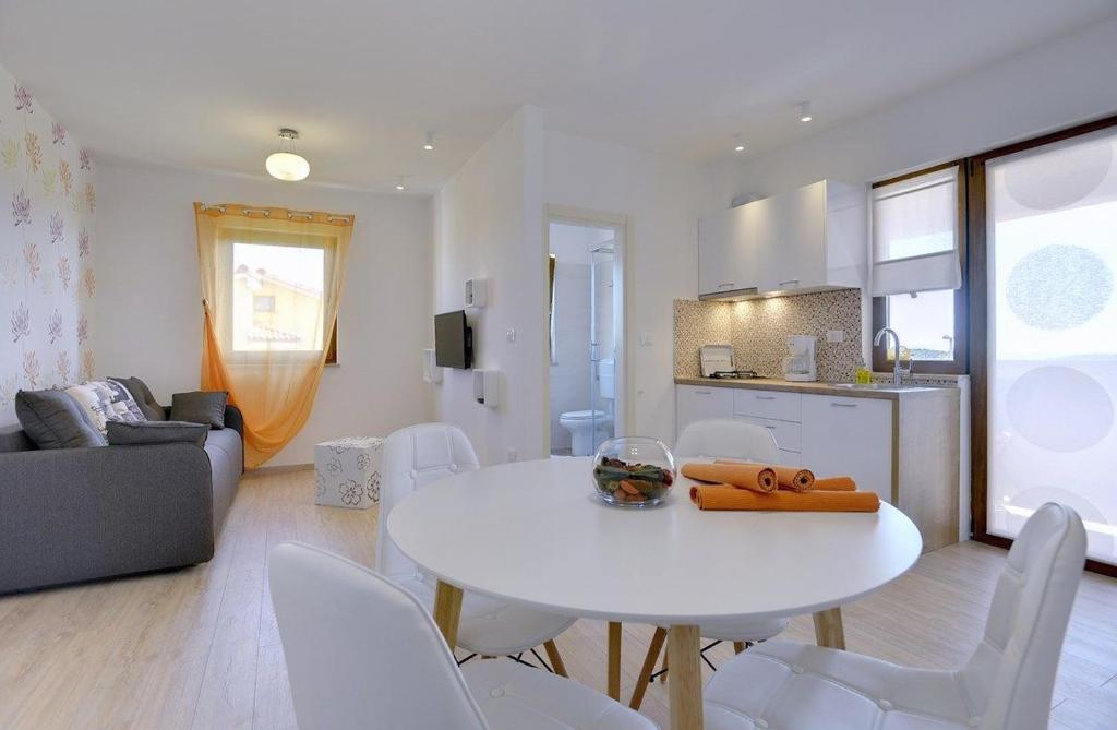 a living room with a white table and white chairs at Apartments Buic in Vinkuran