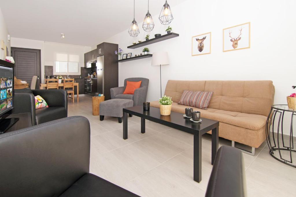 ein Wohnzimmer mit einem Sofa und einem Tisch in der Unterkunft Apartment Malvina in Protaras
