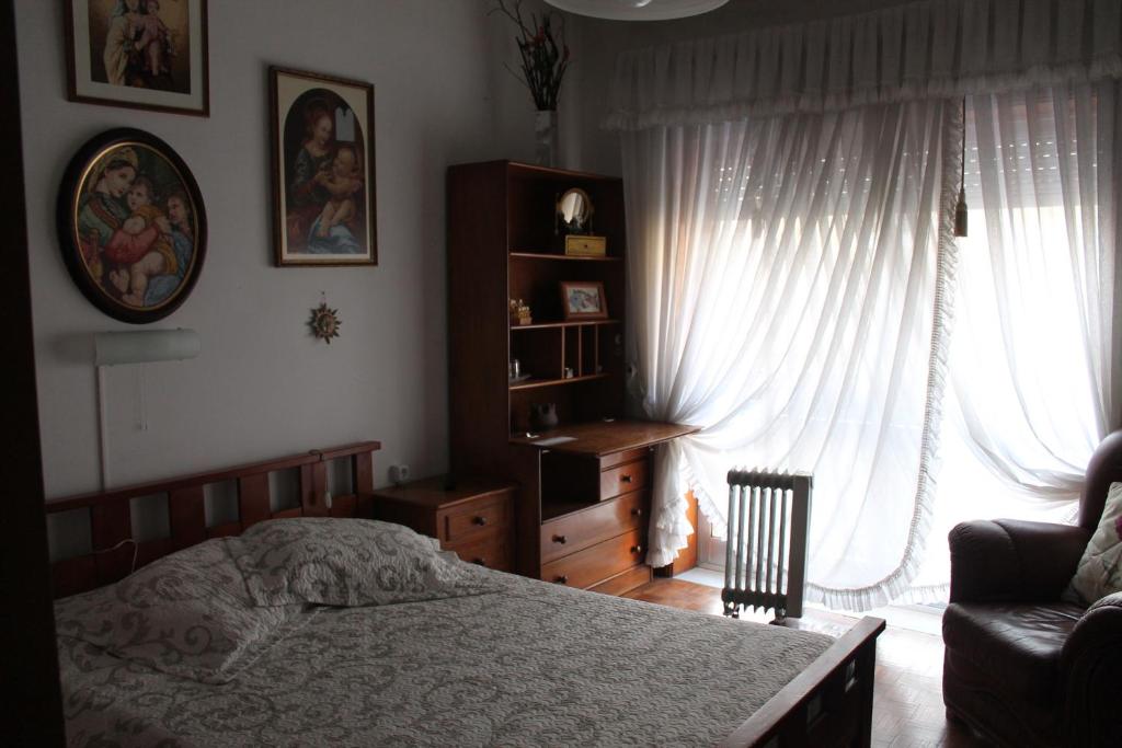 ポルトにあるSuite Portoのベッドルーム1室(ベッド1台、椅子、窓付)