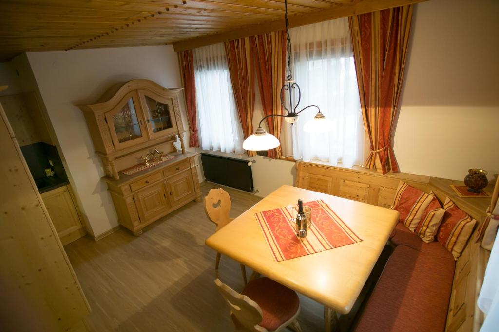 a dining room with a table and a couch and a table and chairs at Appartement Waldhof in Flattach