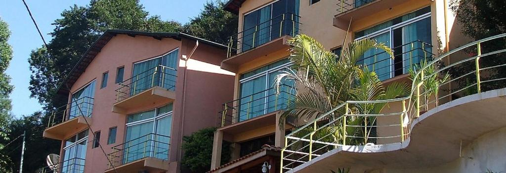 a pink building with plants on the side of it at Pousada Apice in São Luiz do Paraitinga