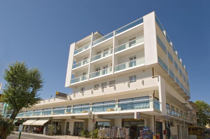 ein großes weißes Gebäude in einer Stadtstraße in der Unterkunft Hotel Igea Spiaggia in Bellaria-Igea Marina