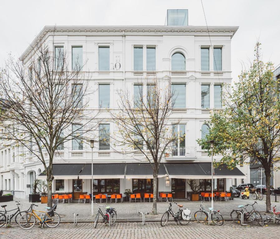 um edifício branco com bicicletas estacionadas em frente em Hotel Pilar em Antuérpia