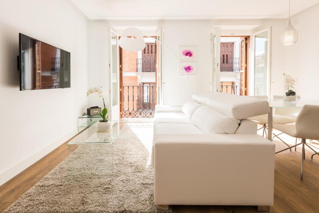 Sala de estar blanca con sofá blanco y mesa en Atocha Boutique - Barrio de las Letras, en Madrid