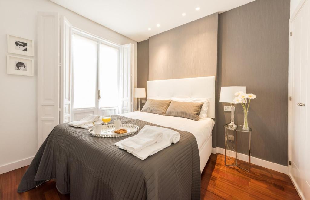 um quarto com uma cama com uma bandeja de comida em Santa Ana Plaza by Madflats Collection em Madri
