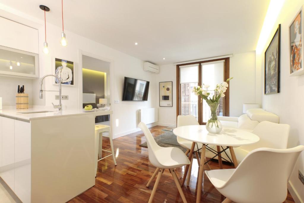 a kitchen and living room with a table and chairs at Malasaña Center by Madflats Collection in Madrid