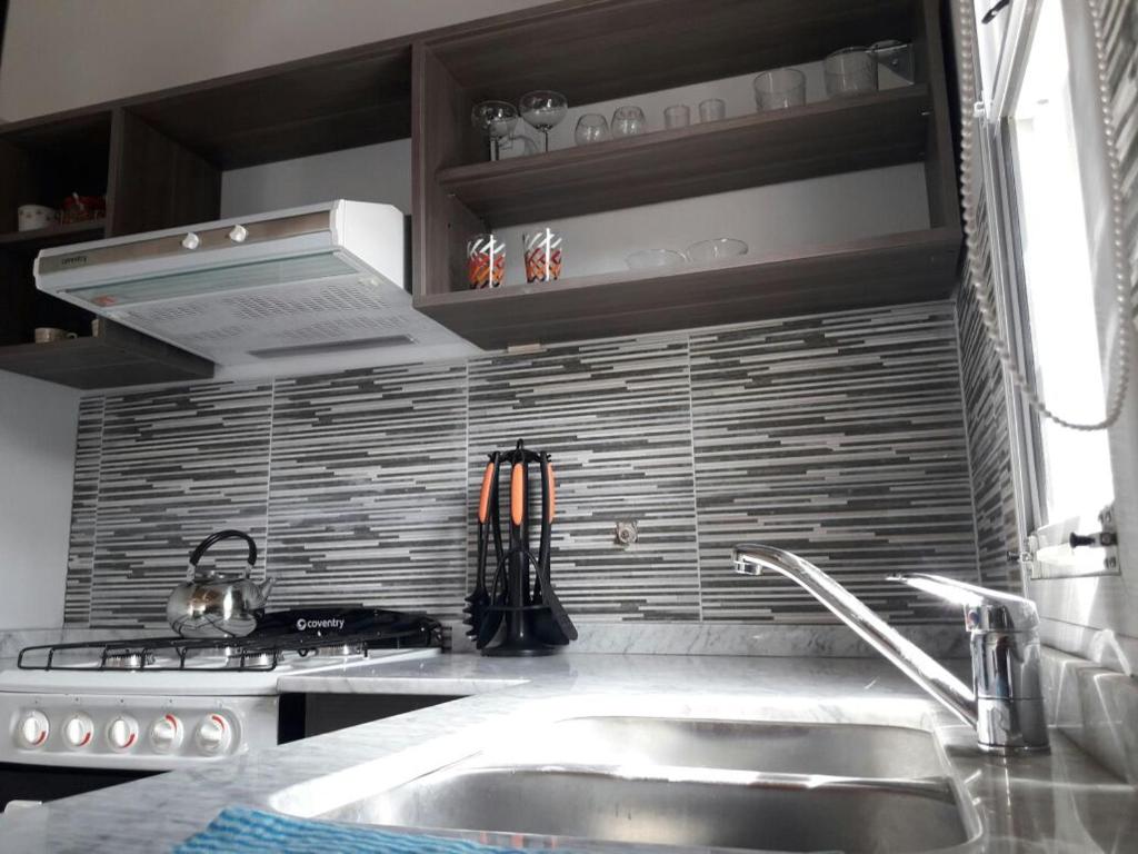 a kitchen with a sink and a stove at brisas de villa gesell in Villa Gesell