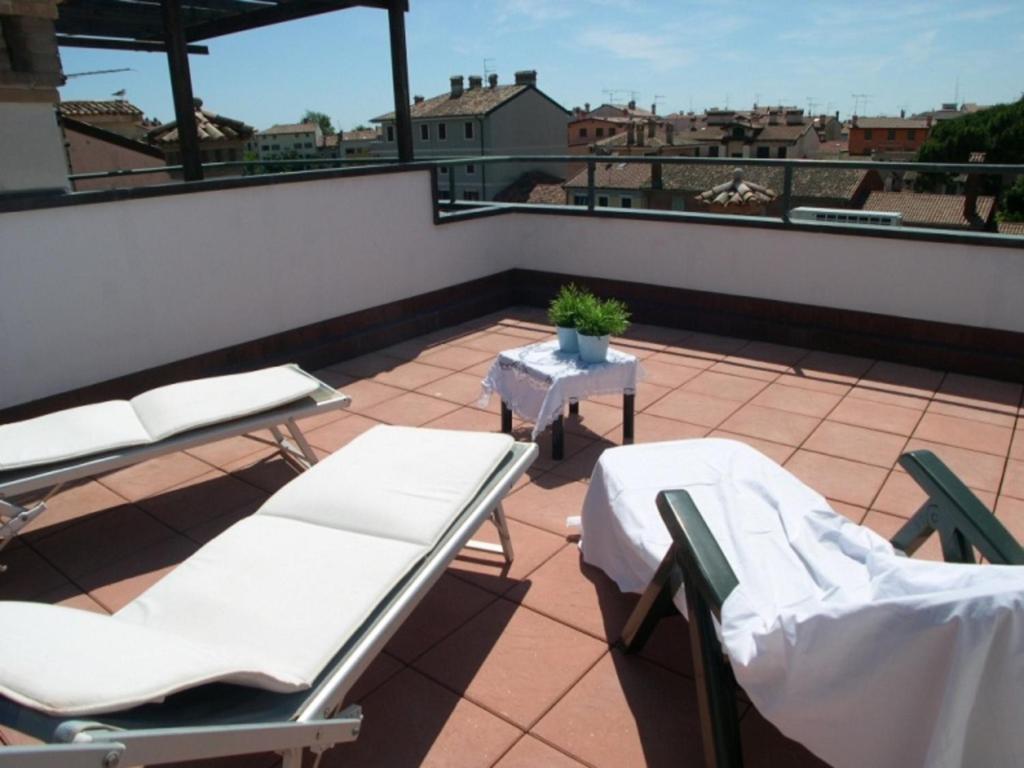 eine Terrasse mit Stühlen und einem Tisch auf dem Dach in der Unterkunft Villa Eleonora in Grado