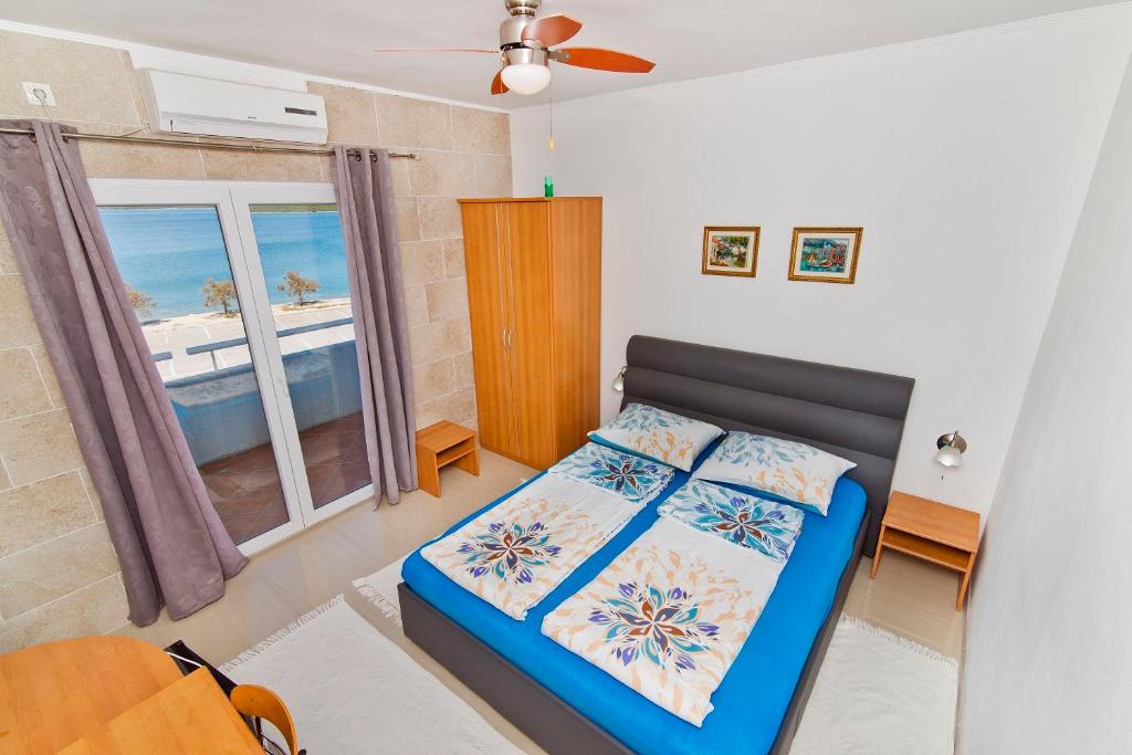 a bedroom with a bed with a view of the ocean at Rooms & Apartments Marinero in Betina