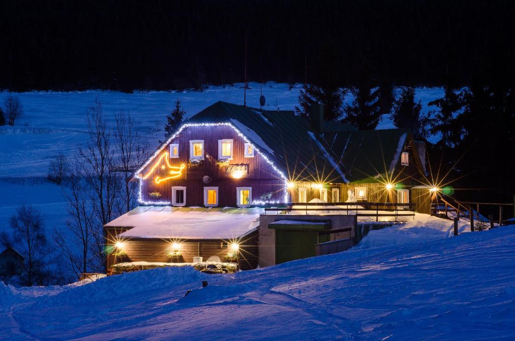 派克波特斯耐兹库Bouda Racek的雪覆盖的房屋,晚上有灯