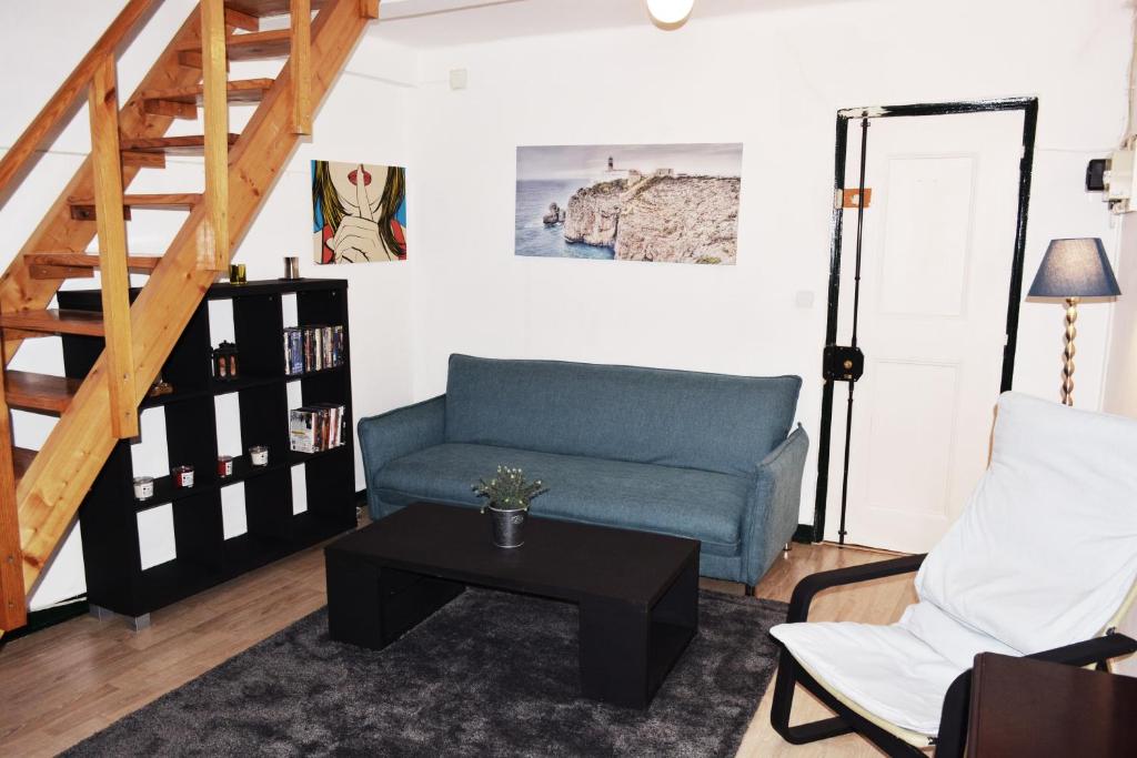 ein Wohnzimmer mit einem blauen Sofa und einem Tisch in der Unterkunft Bairro Alto Central Apartment Lisbon in Lissabon