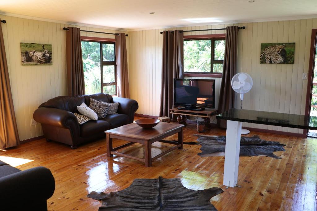 a living room with a couch and a television at Allan Grove in Knysna