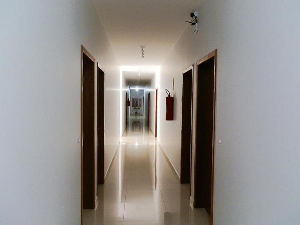 a hallway with white walls and a light on the ceiling at Lisboa Palace Hotel in Alta Floresta