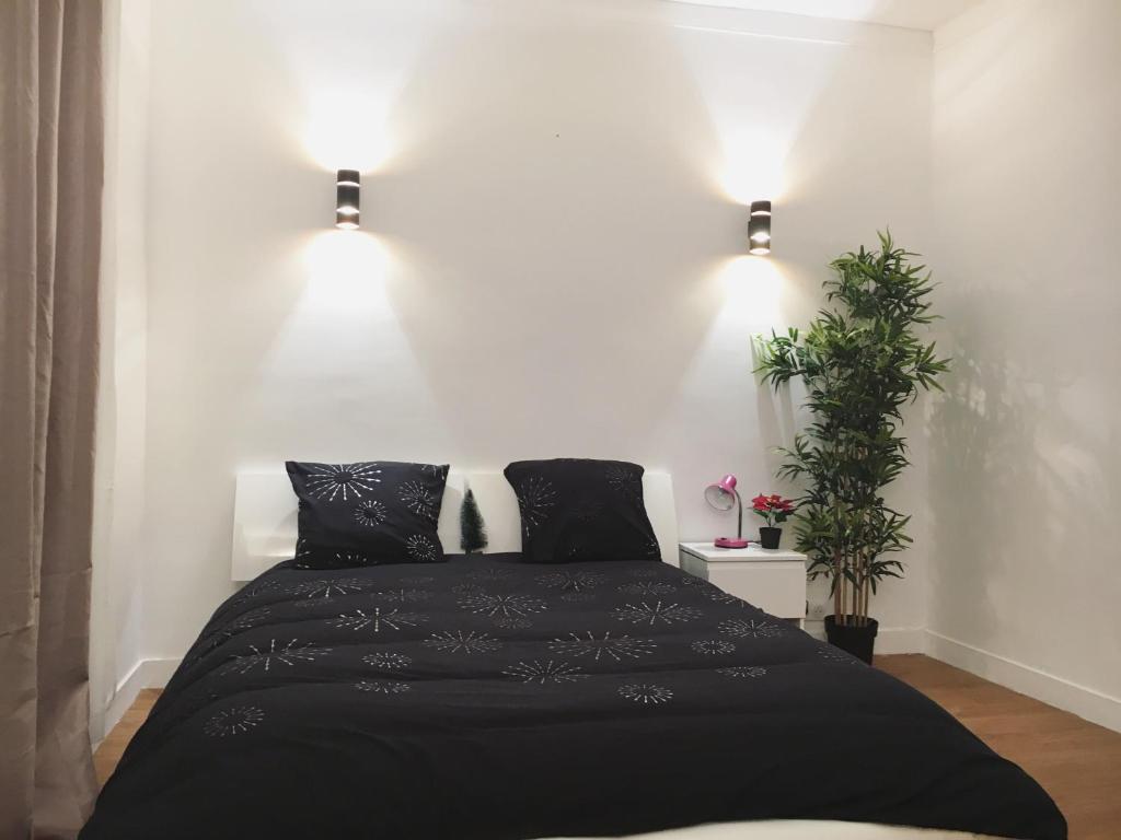 a bedroom with a black bed and two lights at Cosy Apartment near Eiffel Tour in Paris