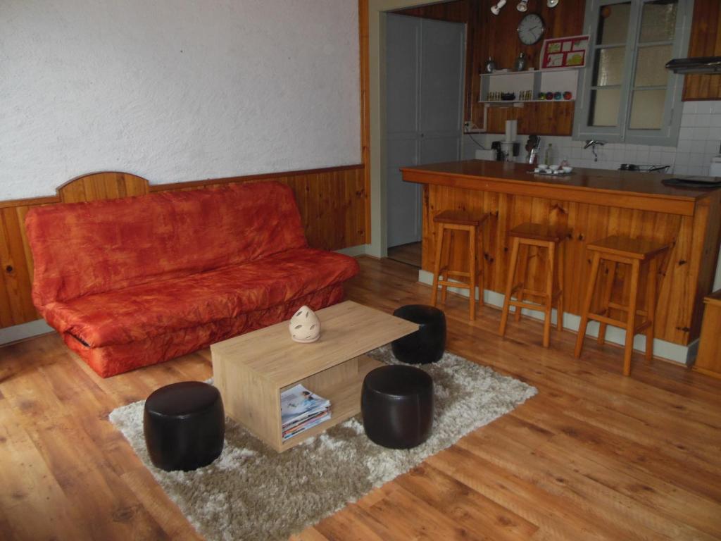 a living room with a red couch and a table at Beau Soleil in Eaux-Bonnes