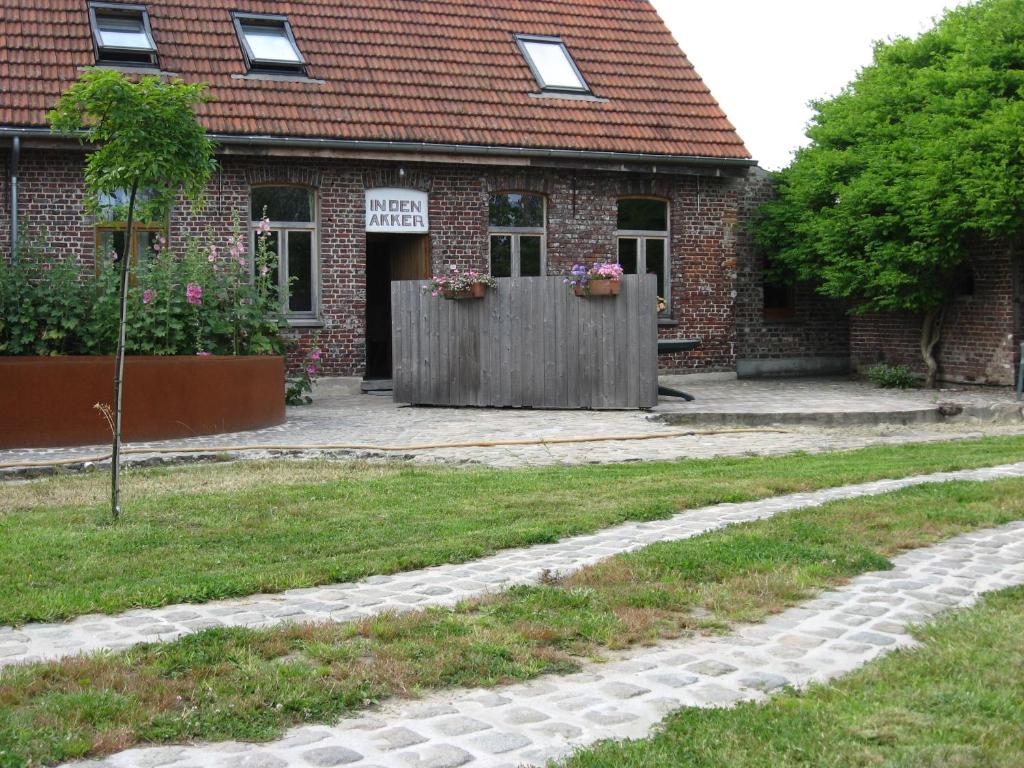 a brick house with a fence in front of a yard at in Den Akker in Oudenaarde
