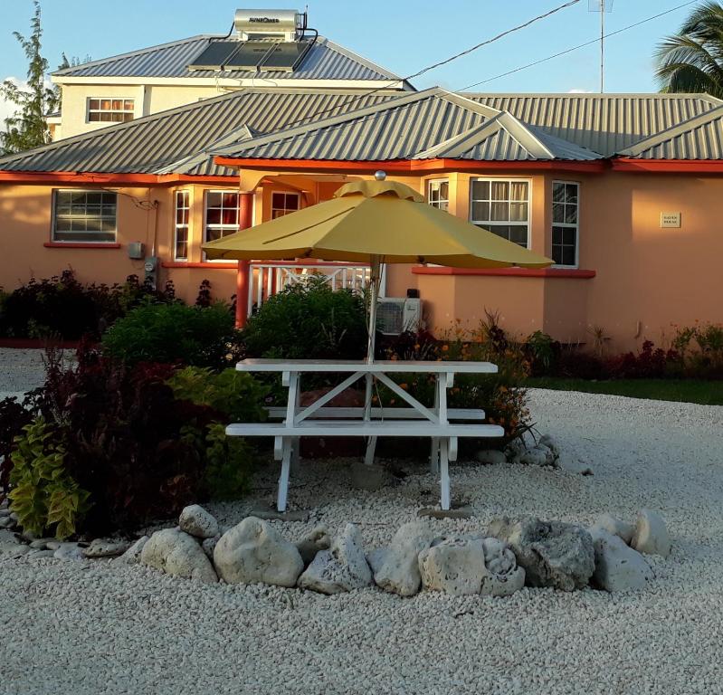 eine Bank mit einem Regenschirm vor einem Haus in der Unterkunft Haven House Apartments in Christchurch