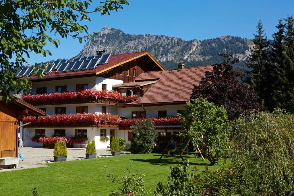 ein Haus mit Sonnenkollektoren auf dem Dach in der Unterkunft Apart & Pension Wassermann inklusive Sommerbergbahnticket in Tannheim