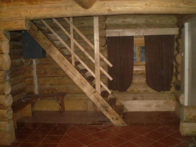 a attic room with a wooden staircase in a house at Huntingbox in Purila