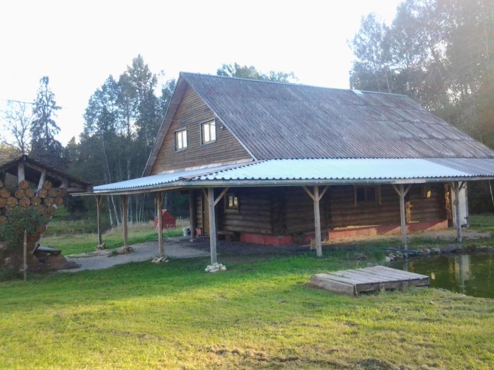 a log cabin with a blue roof on a field at Huntingbox in Purila