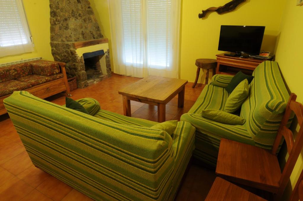 a living room with a green couch and a fireplace at El Taller in San Bartolomé de Tormes