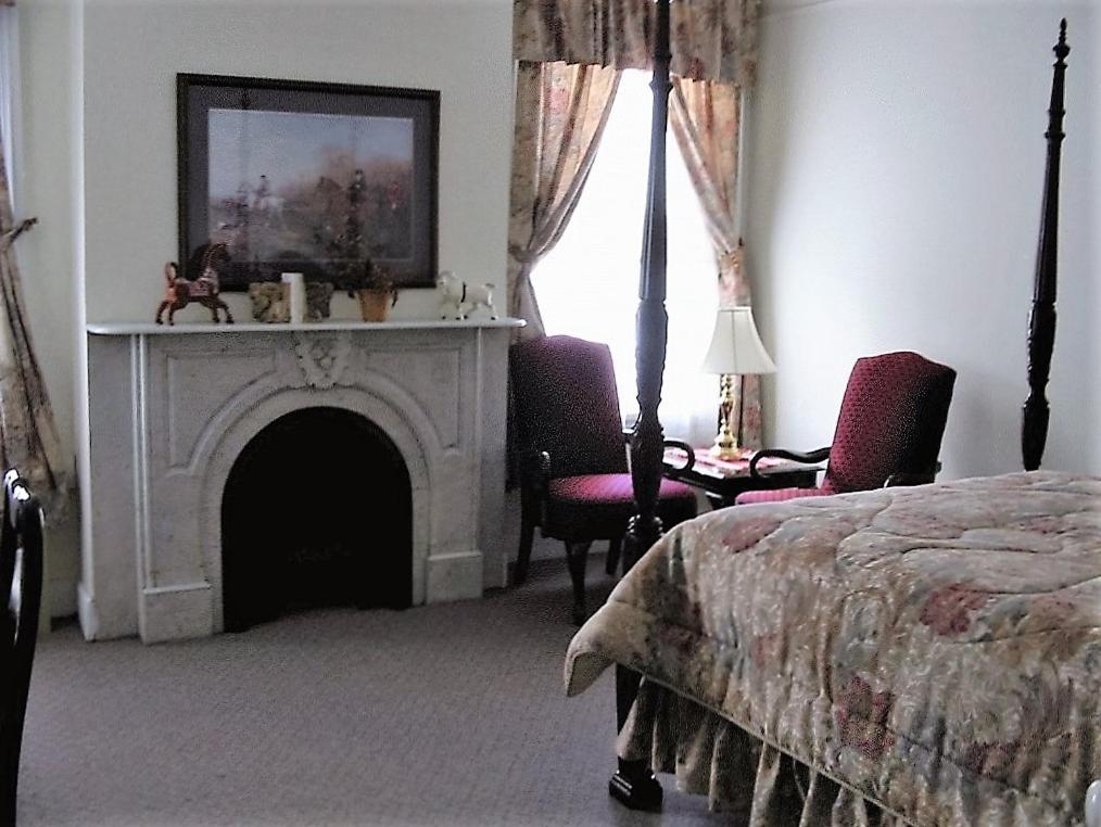a bedroom with a fireplace and a bed and a bed sidx sidx sidx at The Historic Mansion in New Haven